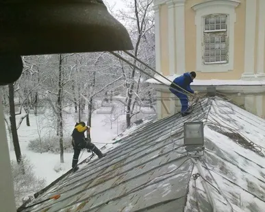 фото Сброс снежных навесов с выступающих элементов фасада