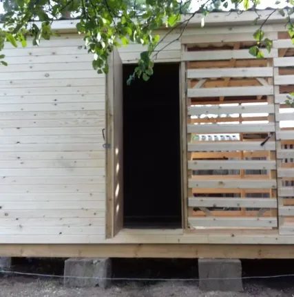 Фото №0 Утепленный сарай с дровником в металлочерепице со сборкой на участке